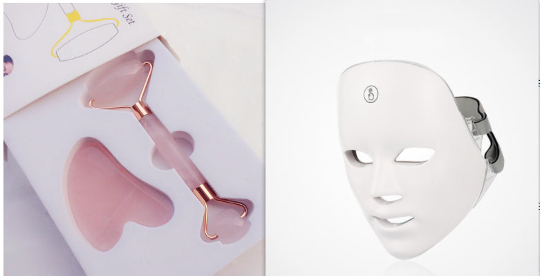 Pink facial roller and gua sha tool on a white background with a white LED face mask.